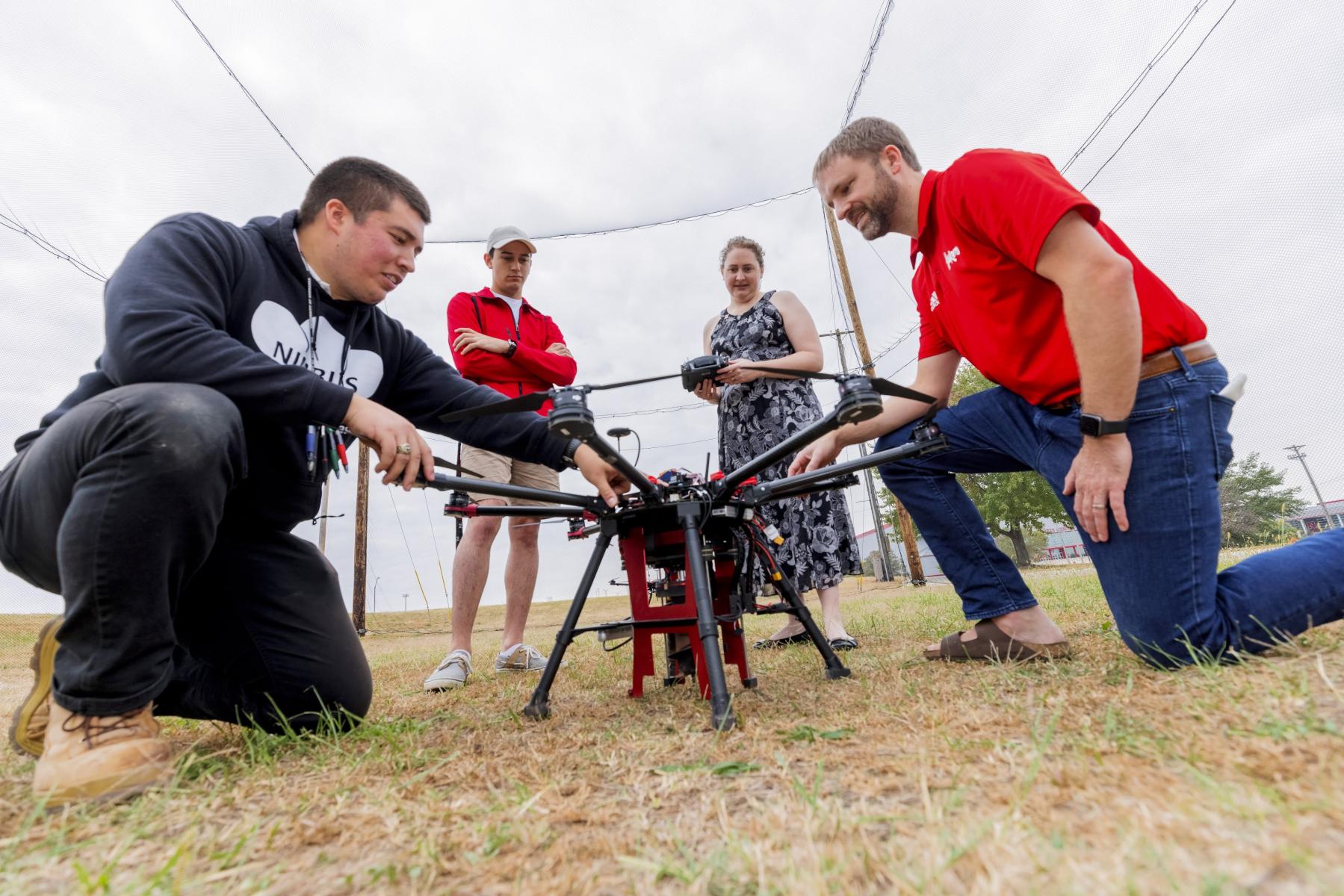 Civil Engineering Students surveying and looking through a tripod.