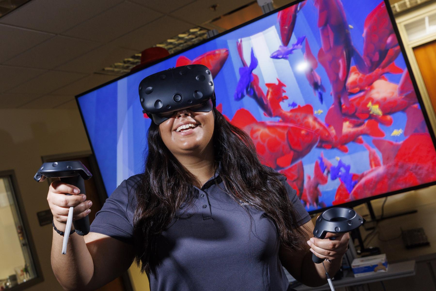 Engineering student looking up with virtual reality equipment.