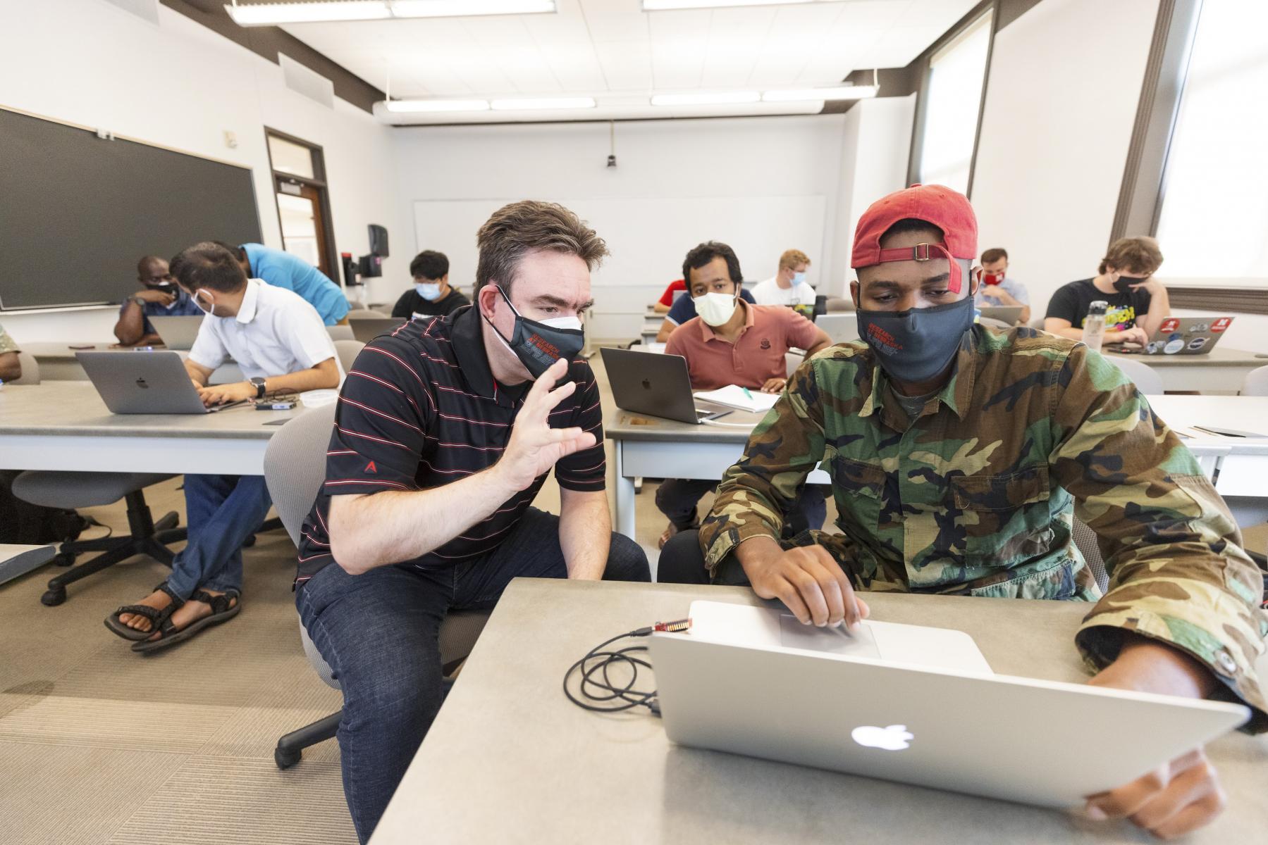 Students conduct an athletic performance study supervised by a professor.