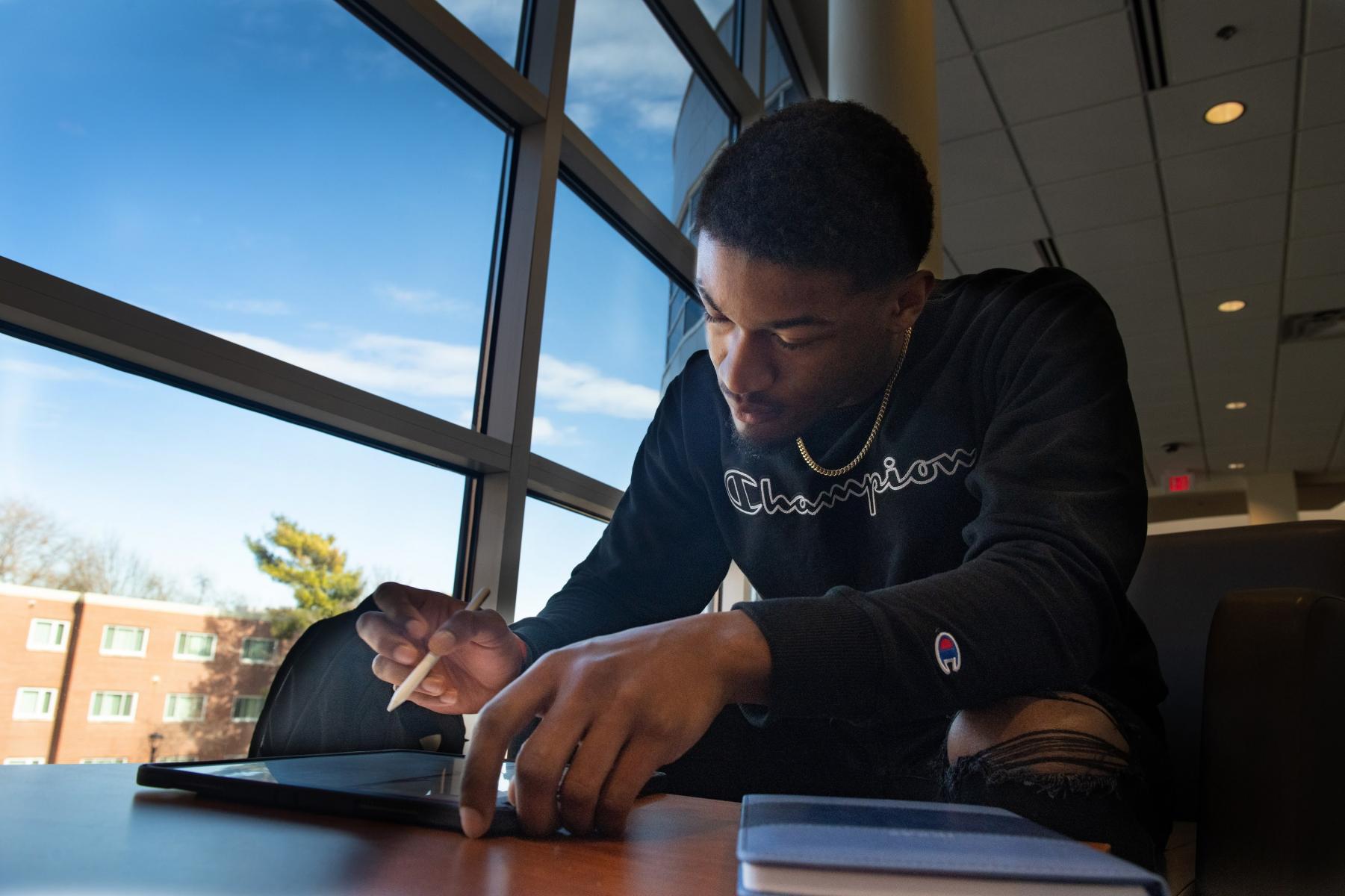 A student reviews photo prints with a professor.