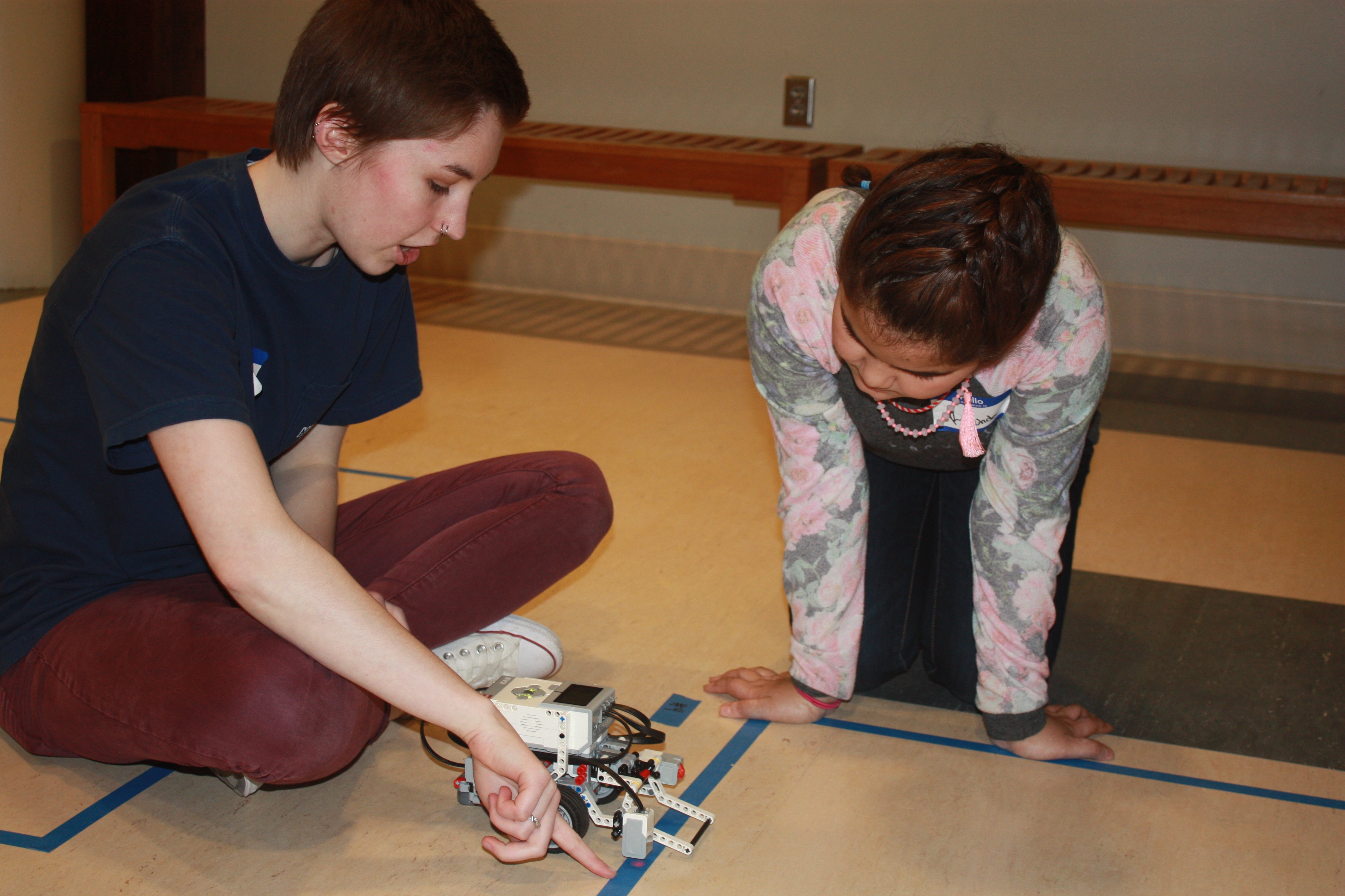 Computing for All member Allison Buckley helps a Girl Scout program a robot.