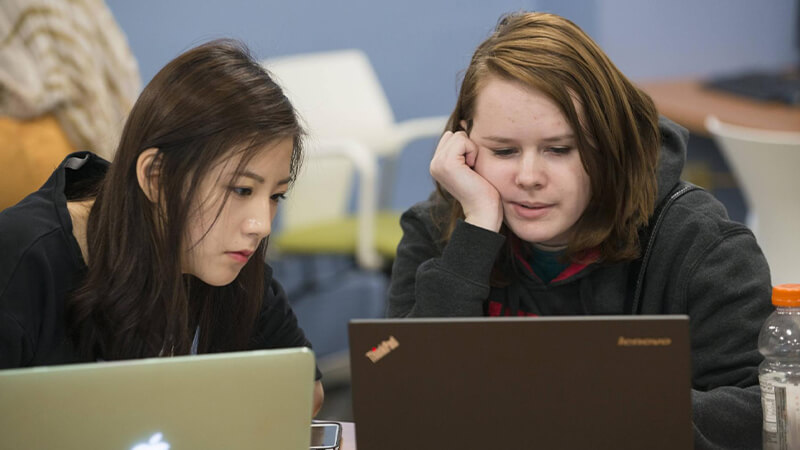 Two students working on a laptop