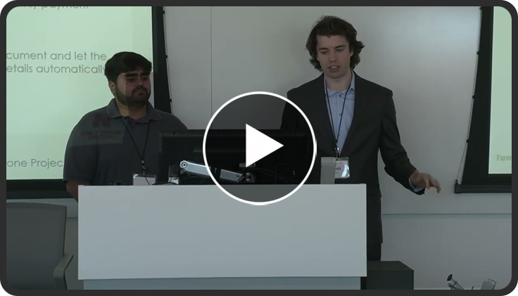 Two people presenting at a podium in a conference room.