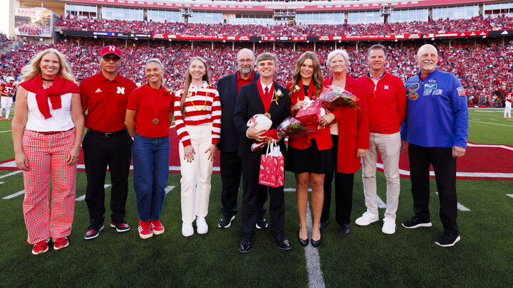 Five men and five women pose for a group photo at midfield of Memorial Stadium.