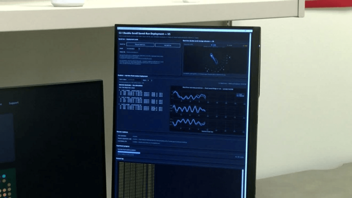Computer monitor displaying scientific data graphs and text in a lab setting.