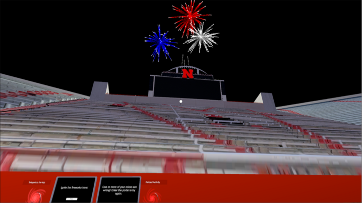 A scene from the Husker STEM VR game of fireworks in red, white, and blue burst over Memorial stadium with a large screen and red "N" logo.